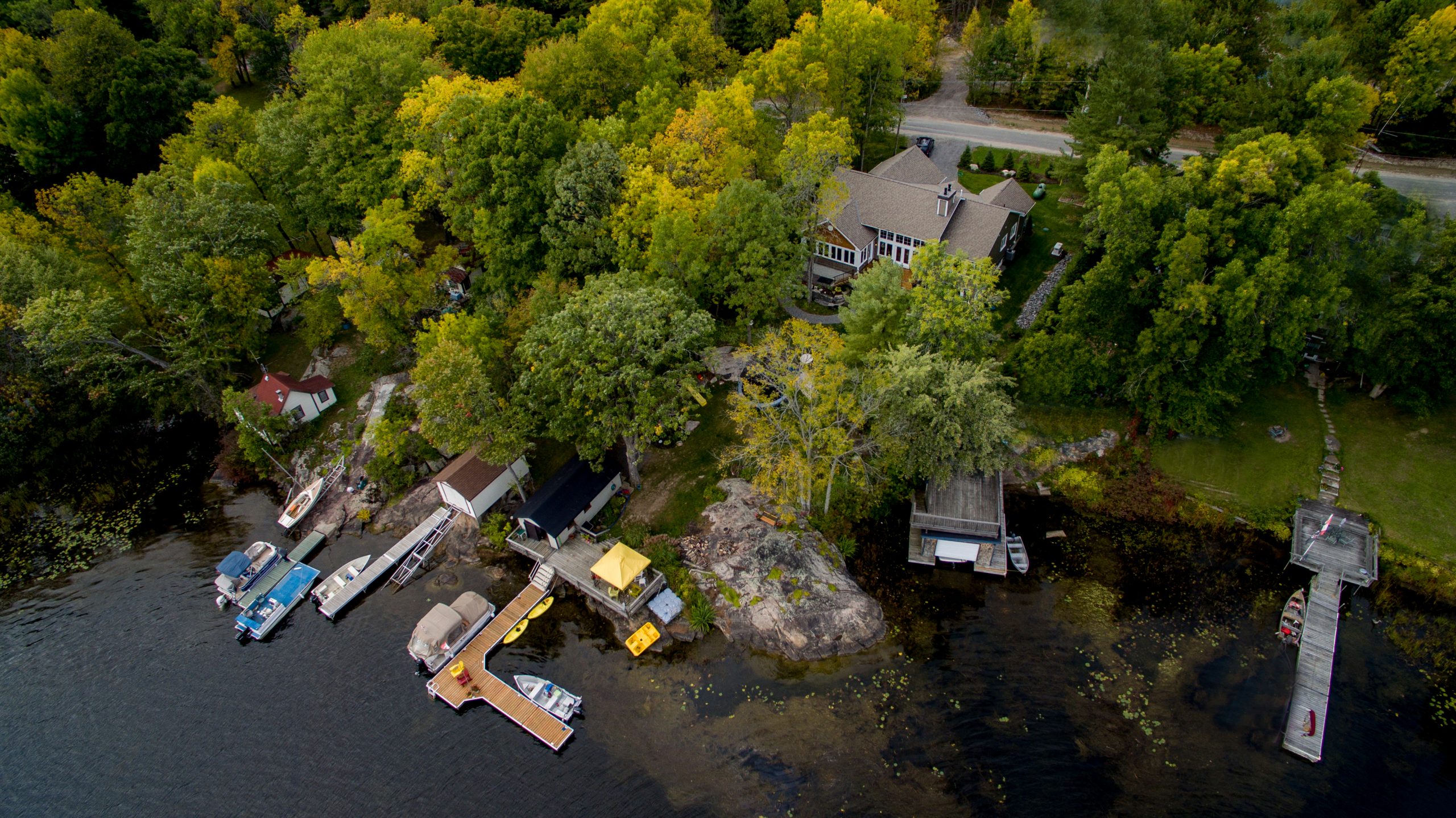 Aerial view of a custom cottage in Central Ontario’s Cottage Country with private docks, shoreline, and surrounding forest.