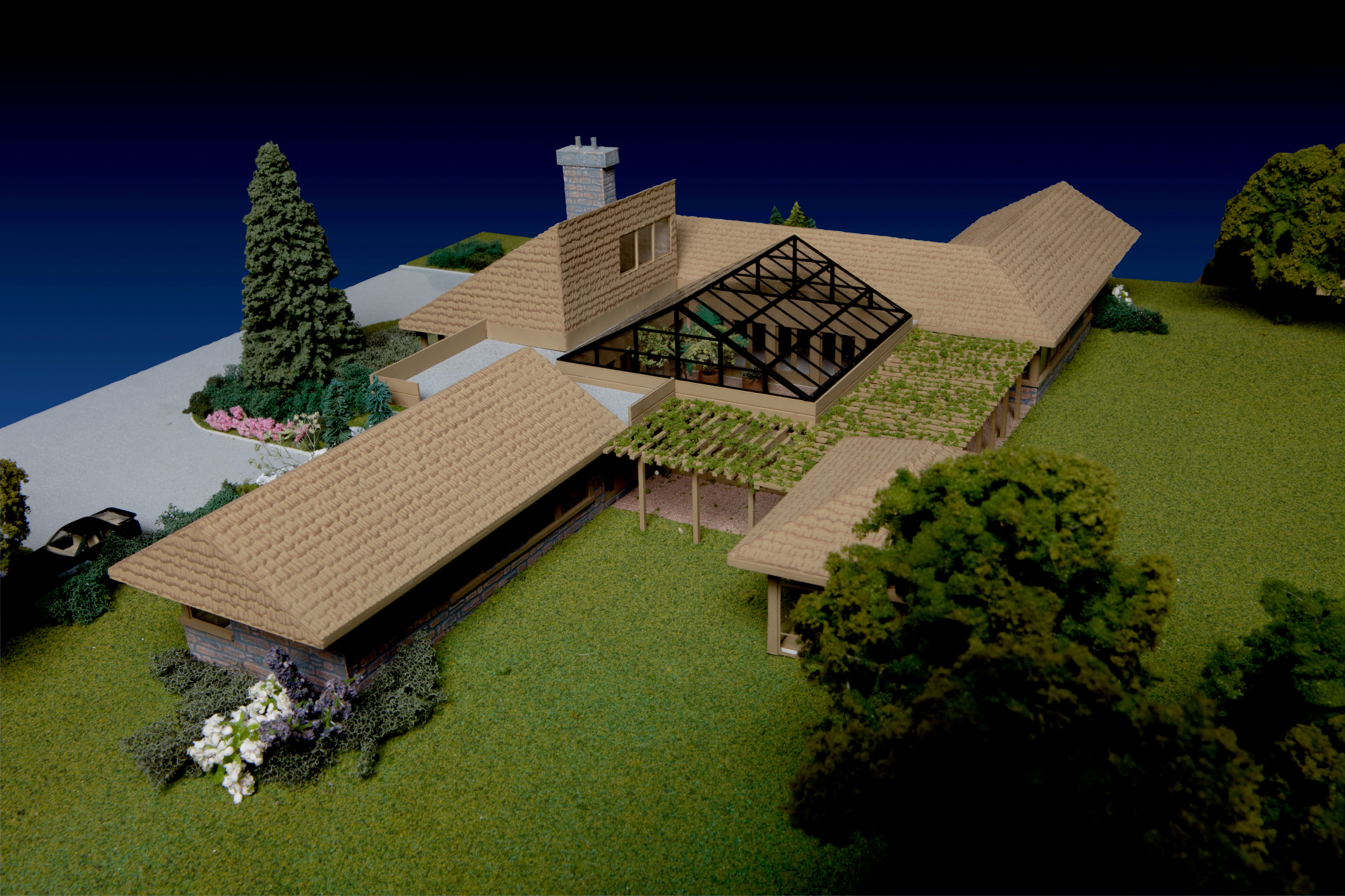 Architectural model illustrating the cost to build a custom cottage in Ontario, featuring detailed rooflines and landscape elements.